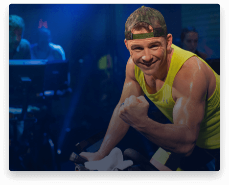 iFit Trainer Adam Pedicini leading a bike workout in the studio.