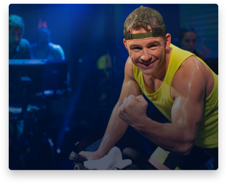 iFit Trainer Adam Pedicini leading a bike workout in the studio.