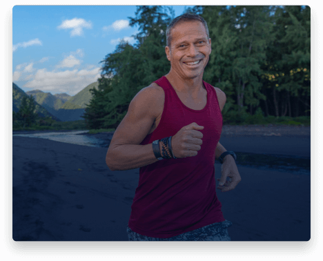 iFit Trainer Chris Clark running on a beach in Hawaii.
