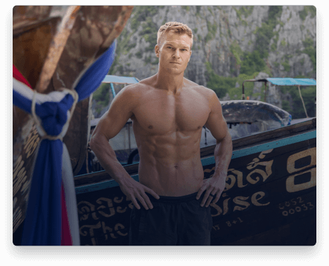 iFit Trainer John Peel standing in front of a boat in Thailand.