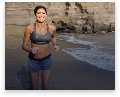 iFit Trainer Stacie Clark running on a beach in Hawaii.